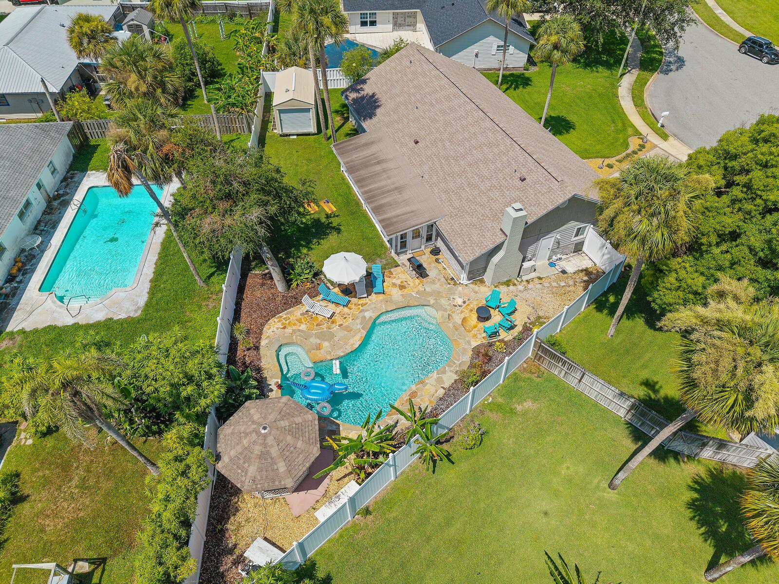 Aerial view of the home, pool, gazebo, and fenced backyard