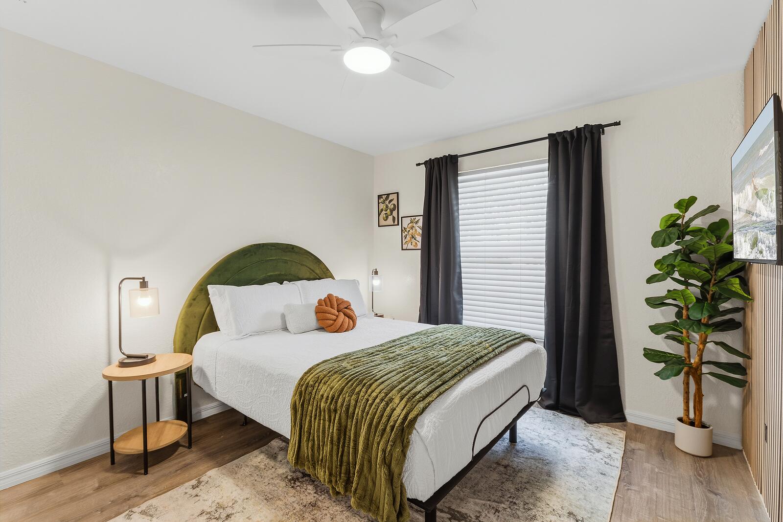 Guest bedroom with arched green velvet headboard
